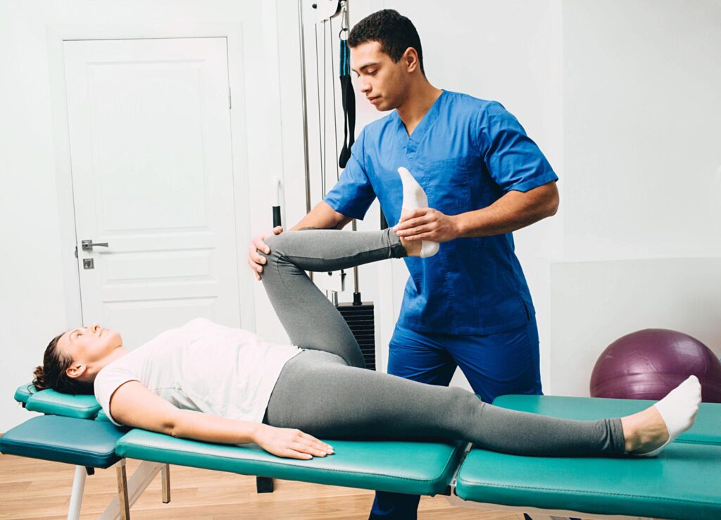 Physiotherapist demonstrating a gentle lower back exercise in a patient's home